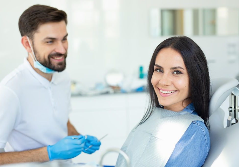 portrait of smiling client and male dentist in dental office